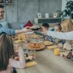 family sitting around table eating dinner
