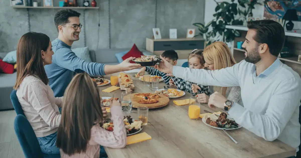 family sitting around table eating dinner